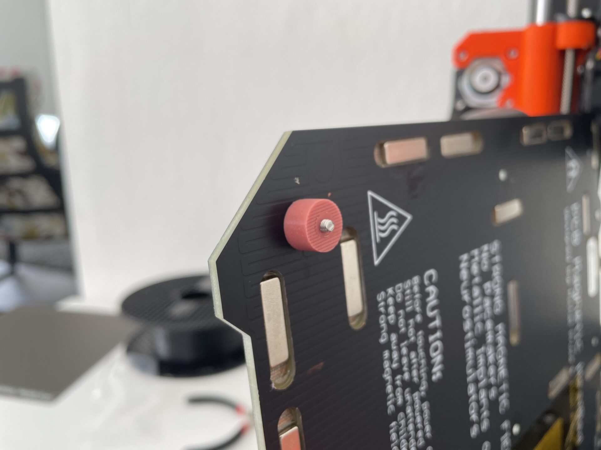 Detailaufnahme eines eingebauten roten Silikondämpfers am Prusa-Heizbett