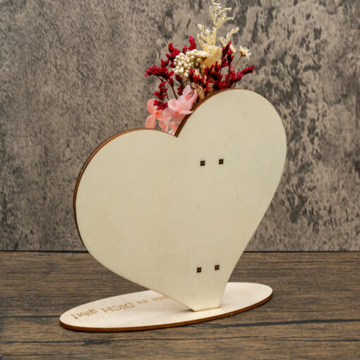 Seitenansicht eines Holzherzens mit Reagenzglas und Trockenblumen